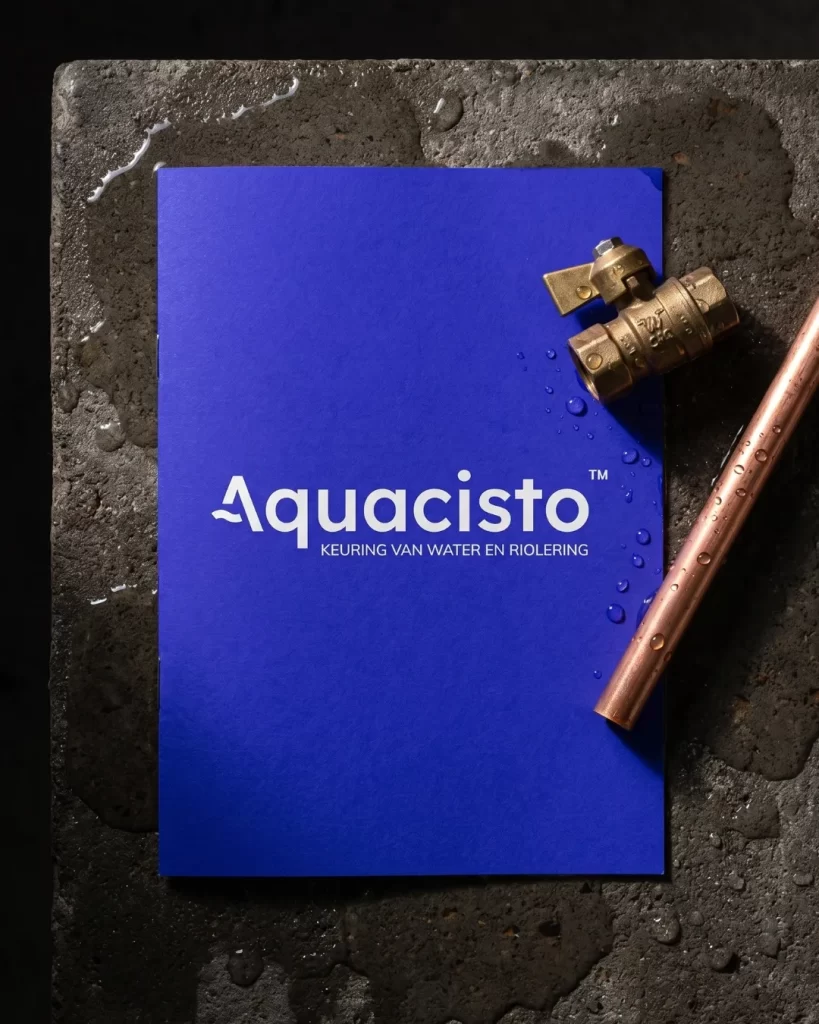 Blauwe map van Aquacisto met wit logo naast een koperen kraan en leiding op natte steen